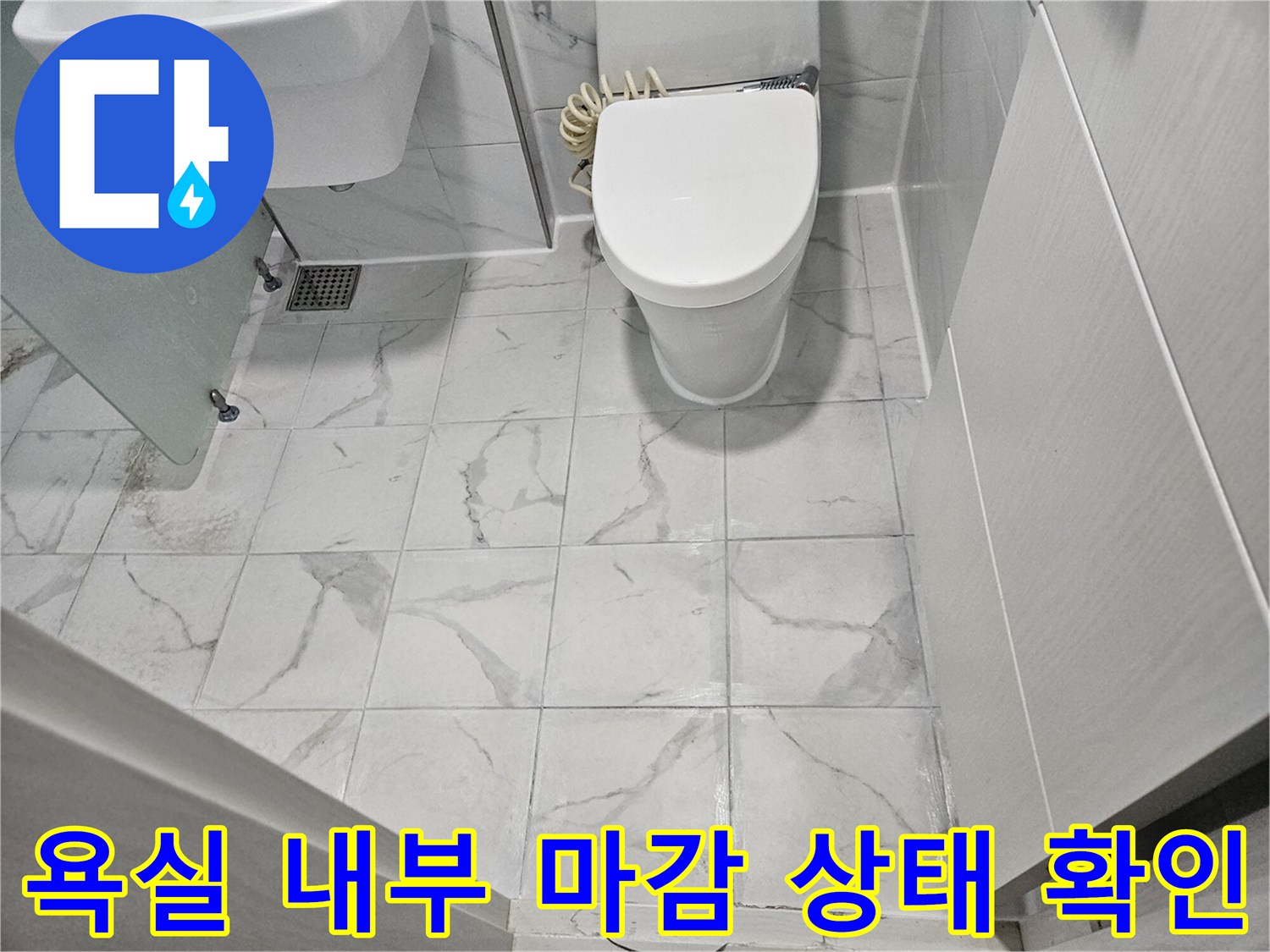 흰색 대리석 패턴 타일이-깔린 화장실 바닥과 위생기구들