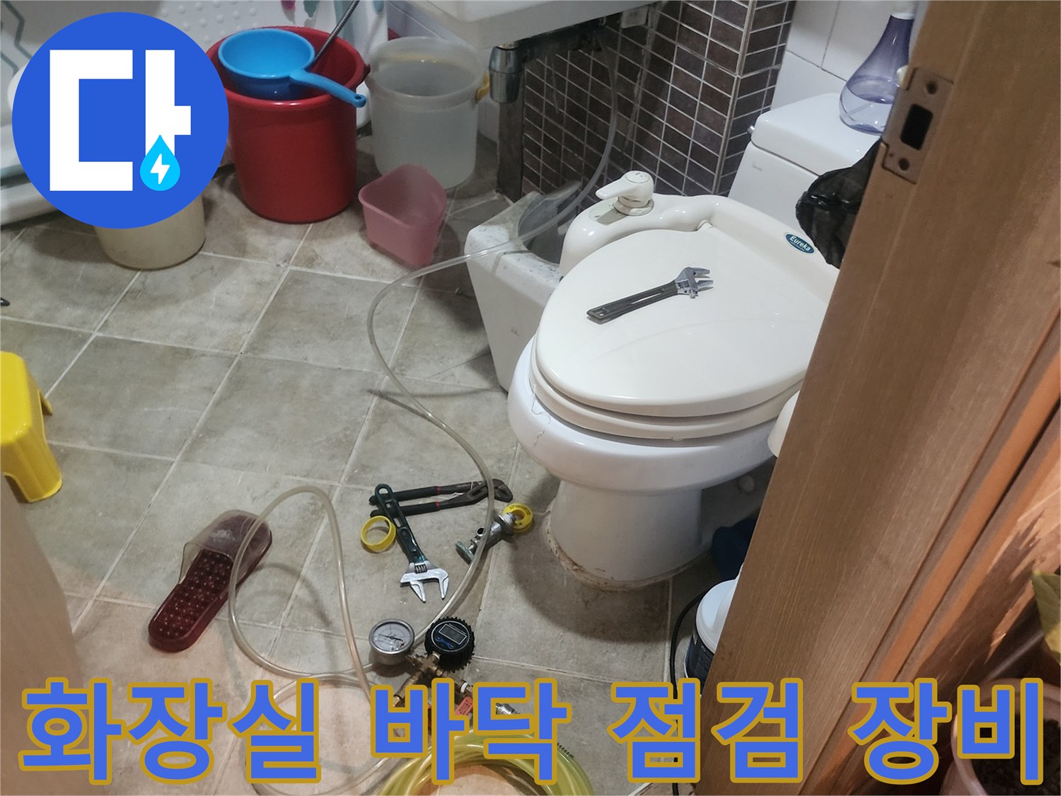 욕실-바닥에-놓인-배관-점검용-압력계-와-호스