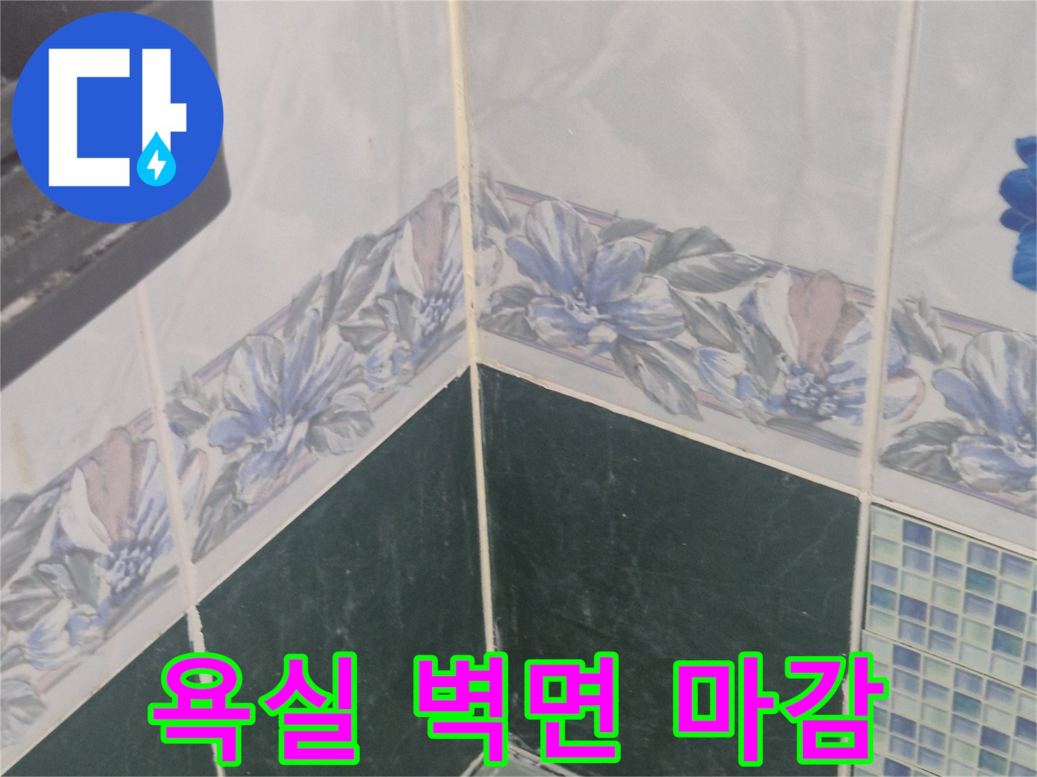 벽면 꽃무늬 타일과 어두운색 타일의 접합부