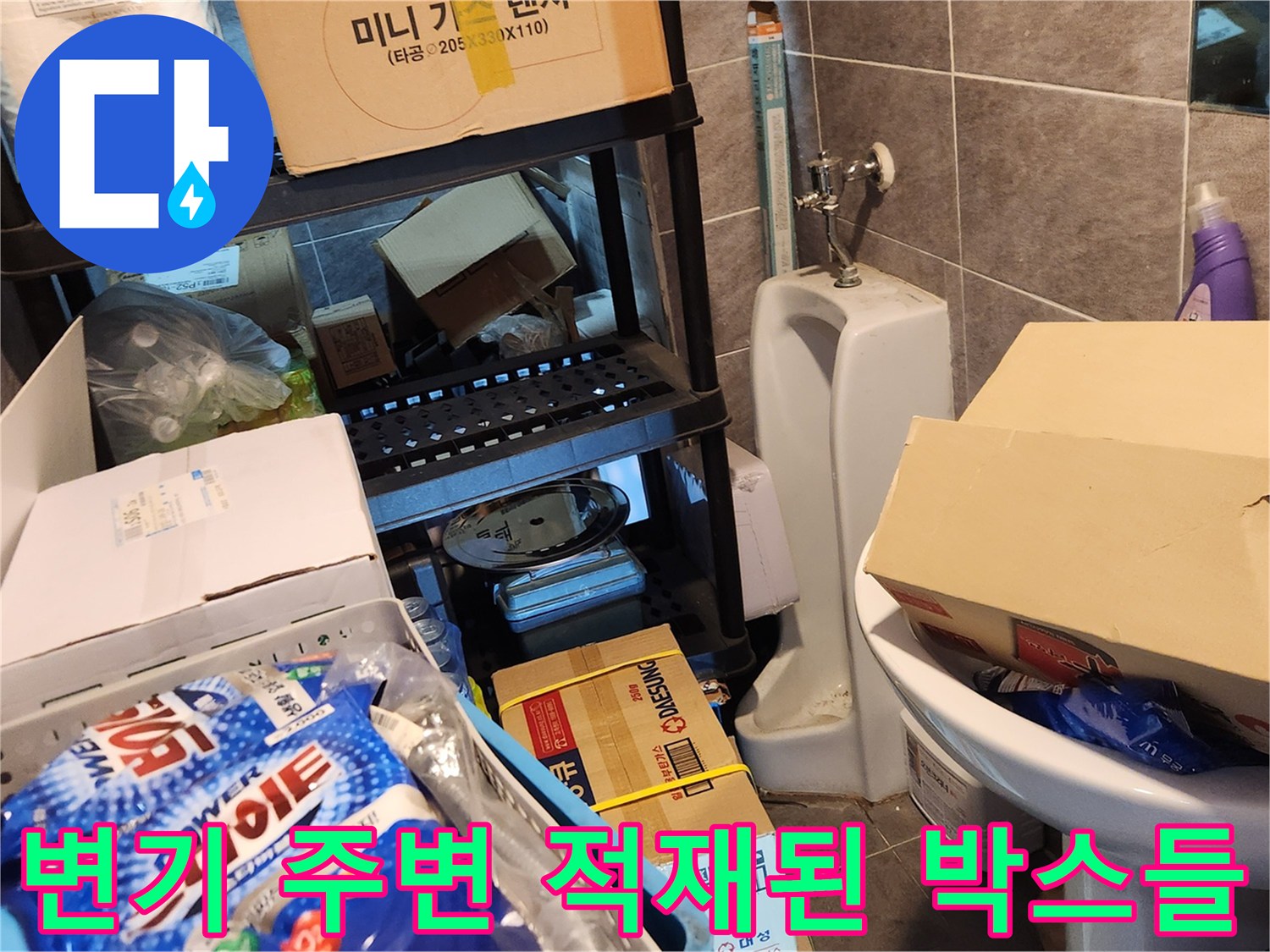 박스와 물품이 쌓인 창고 내 변기 설치 모습