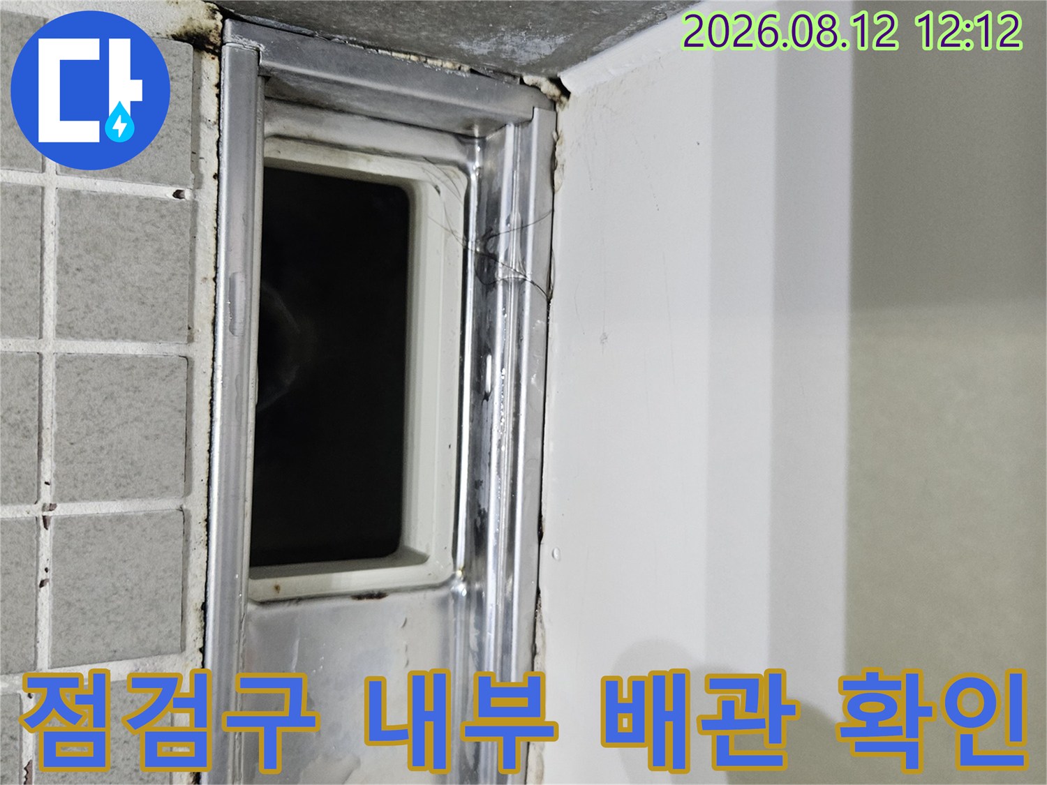 화장실 천장 점검구 안쪽의 금속 프레임과 어두운 배관 공간입니다.