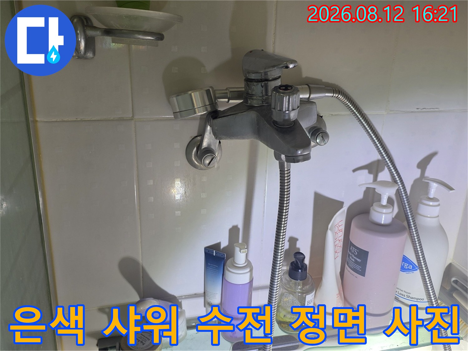 다양한 세면도구가 놓인 선반 위로 설치된 욕실 샤워기-사진