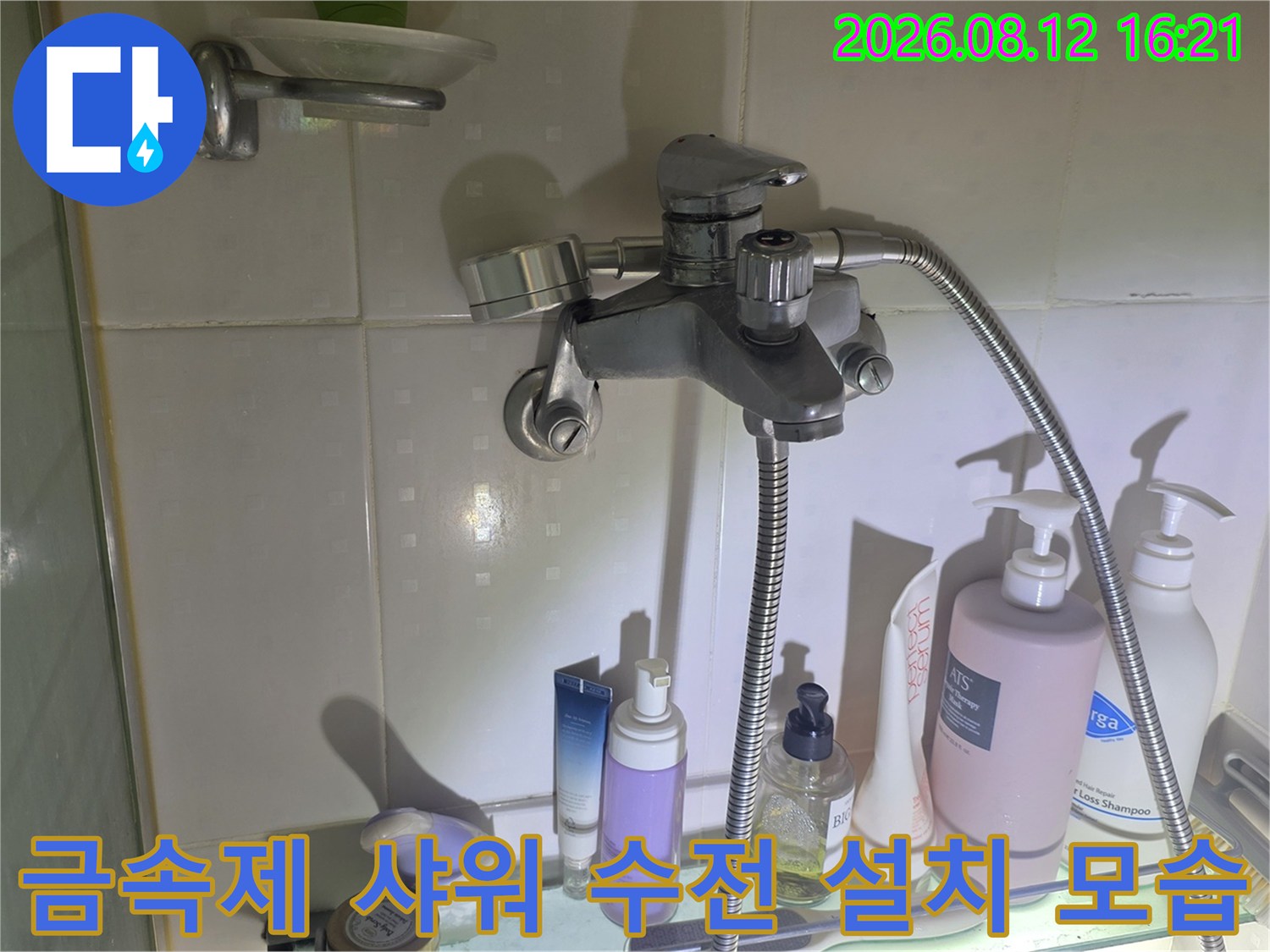 욕실 내 벽면에 고정된 금속 재질의 샤워기 수전과 연결 배관-현장 진단 사진