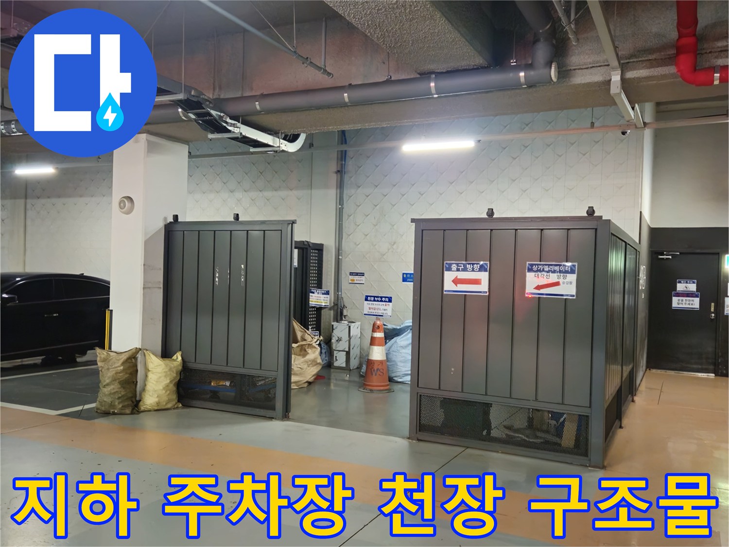 주차장 내부의 은색 배관과 붉은 소방 배관 시설물