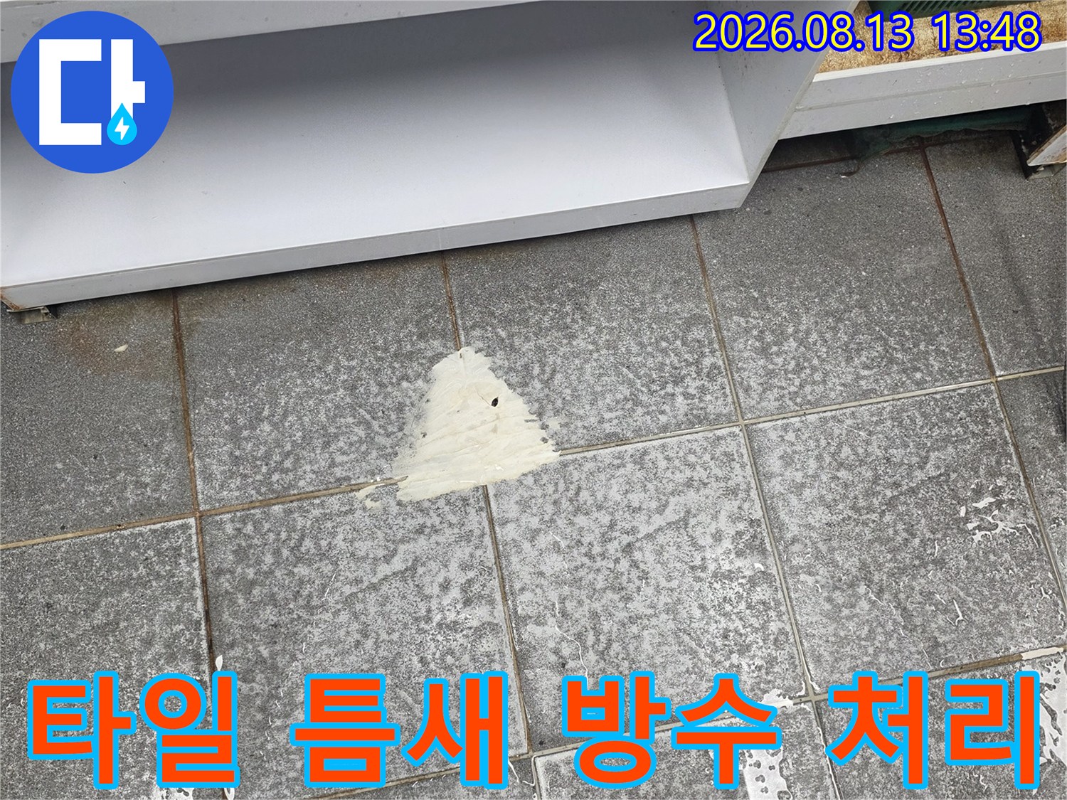 회색 타일 바닥에 하얀 보수재가 발라진 모습
