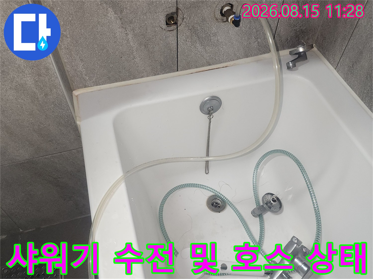 욕실 내 설치된 샤워기 수전과 연결된 호스의 모습