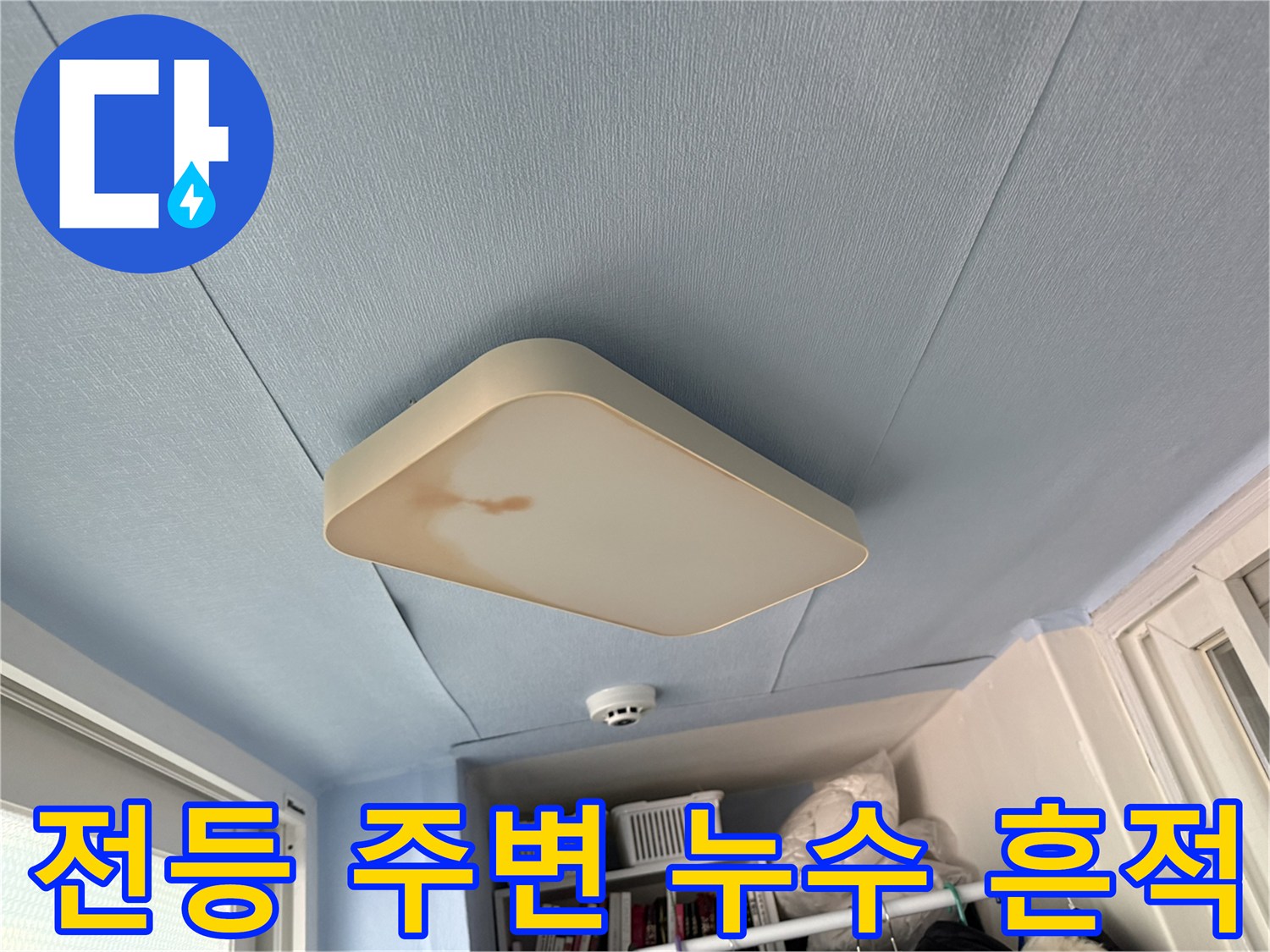 아파트 베란다 전등 주변에 발생한 갈색 누수 얼룩 사진입니다.