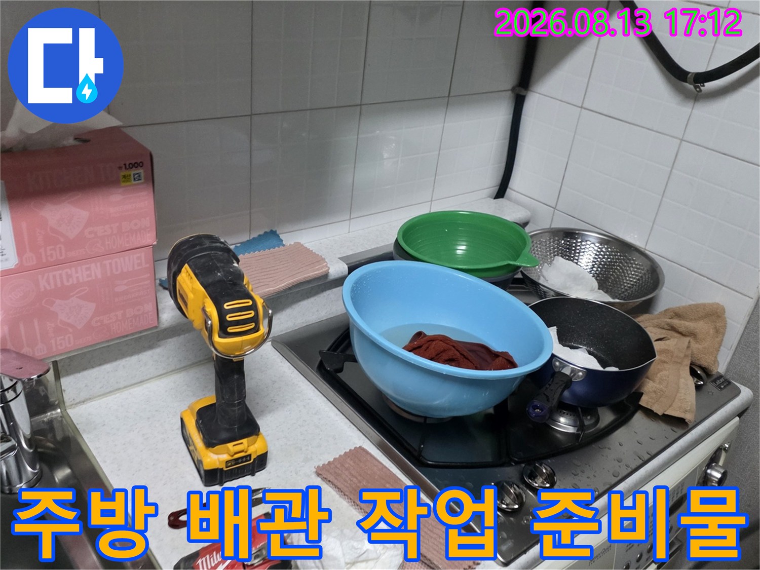 노란색 전동 드릴과 조리대 위 키친타월 및 그릇들