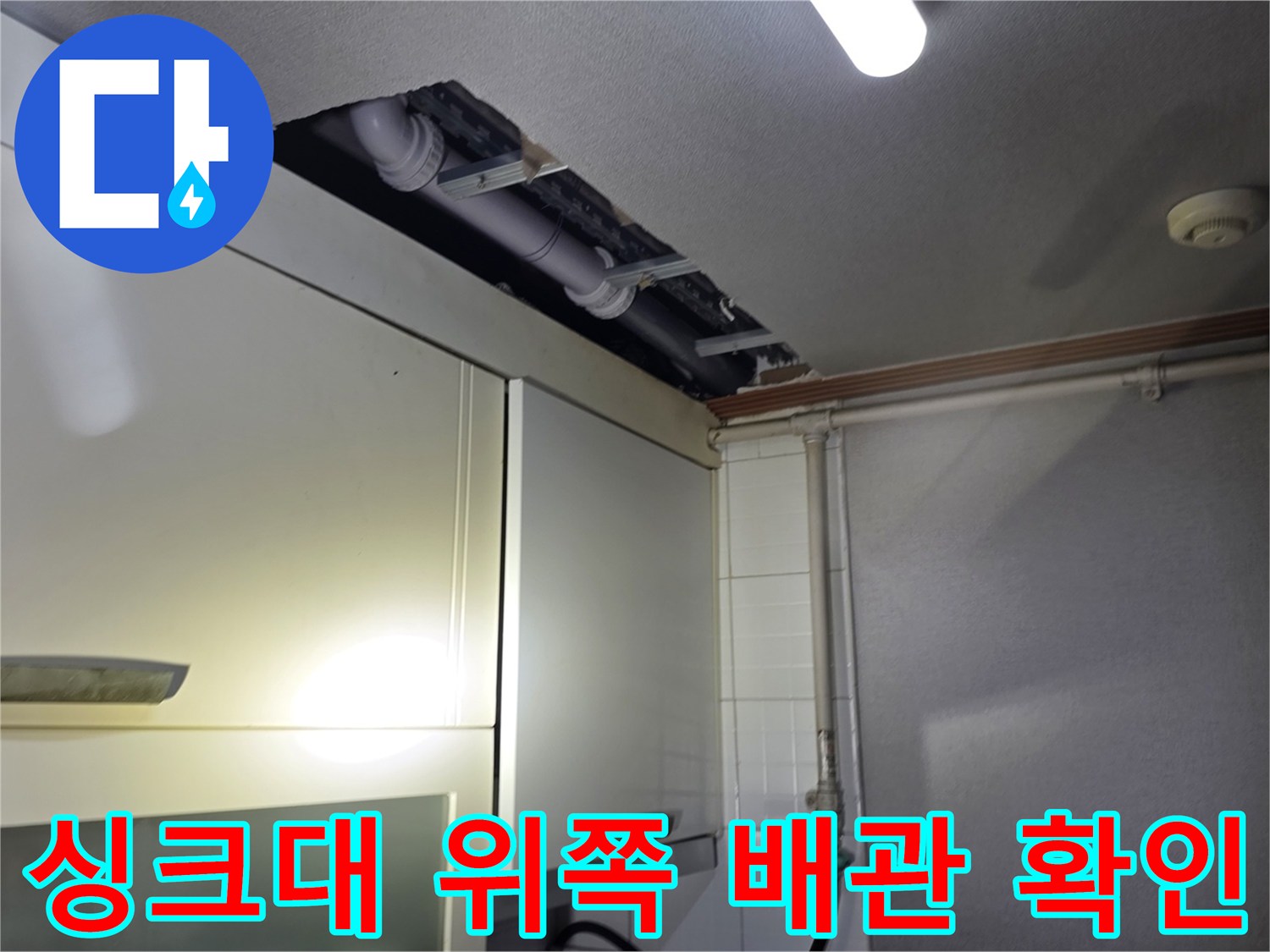 주방 싱크대 상단 가구 사이의 노출된 배관 모습