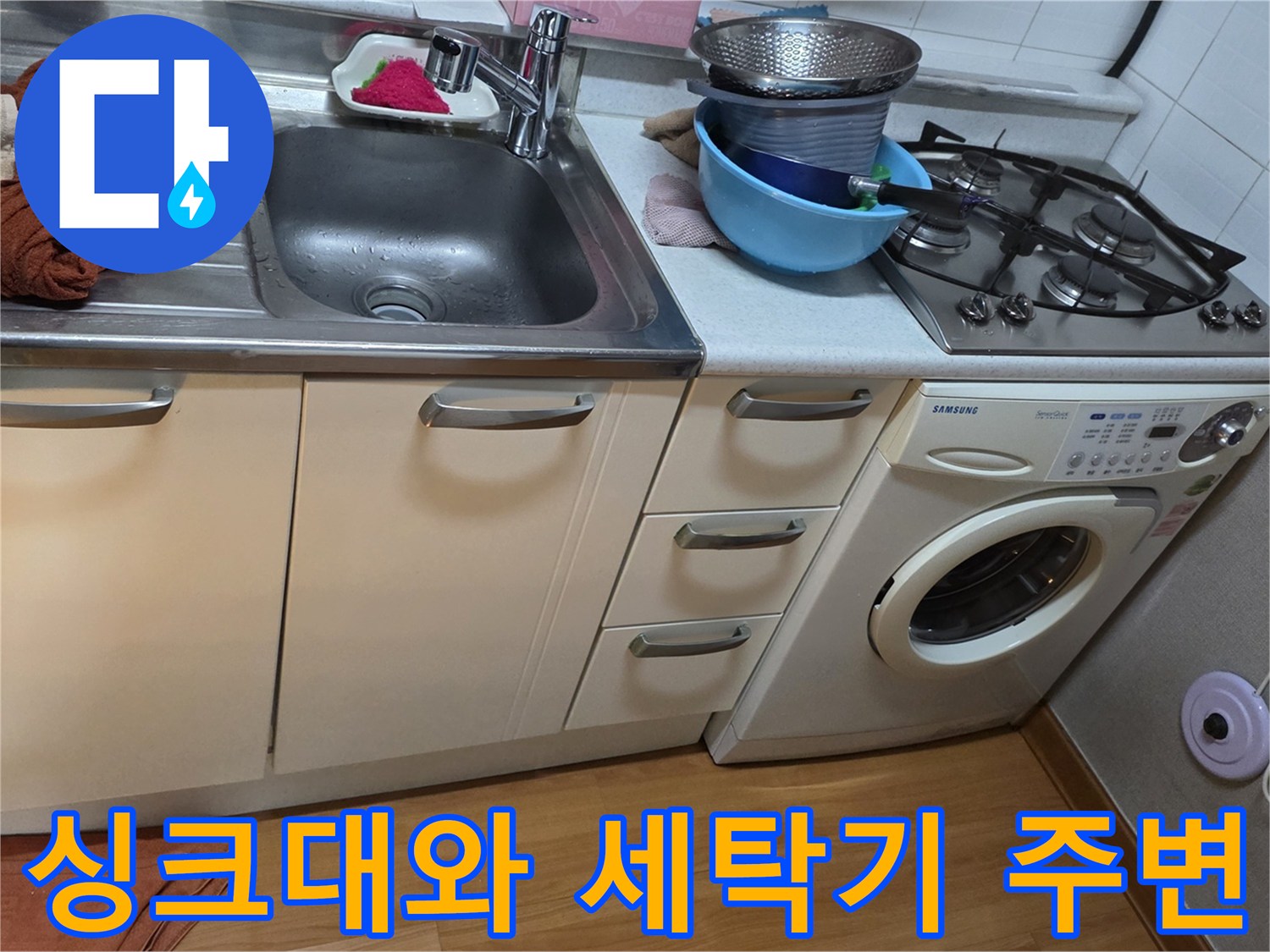 주방 싱크대와 세탁기가 나란히 배치된 모습입니다.