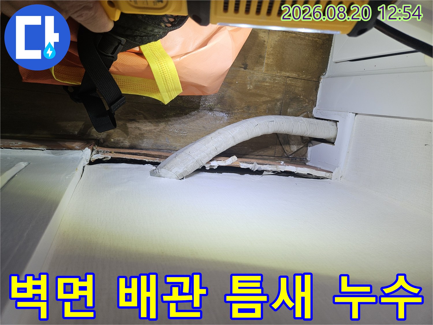 배관과 벽체 사이의 벌어진 틈새를 근접 촬영한 이미지입니다.