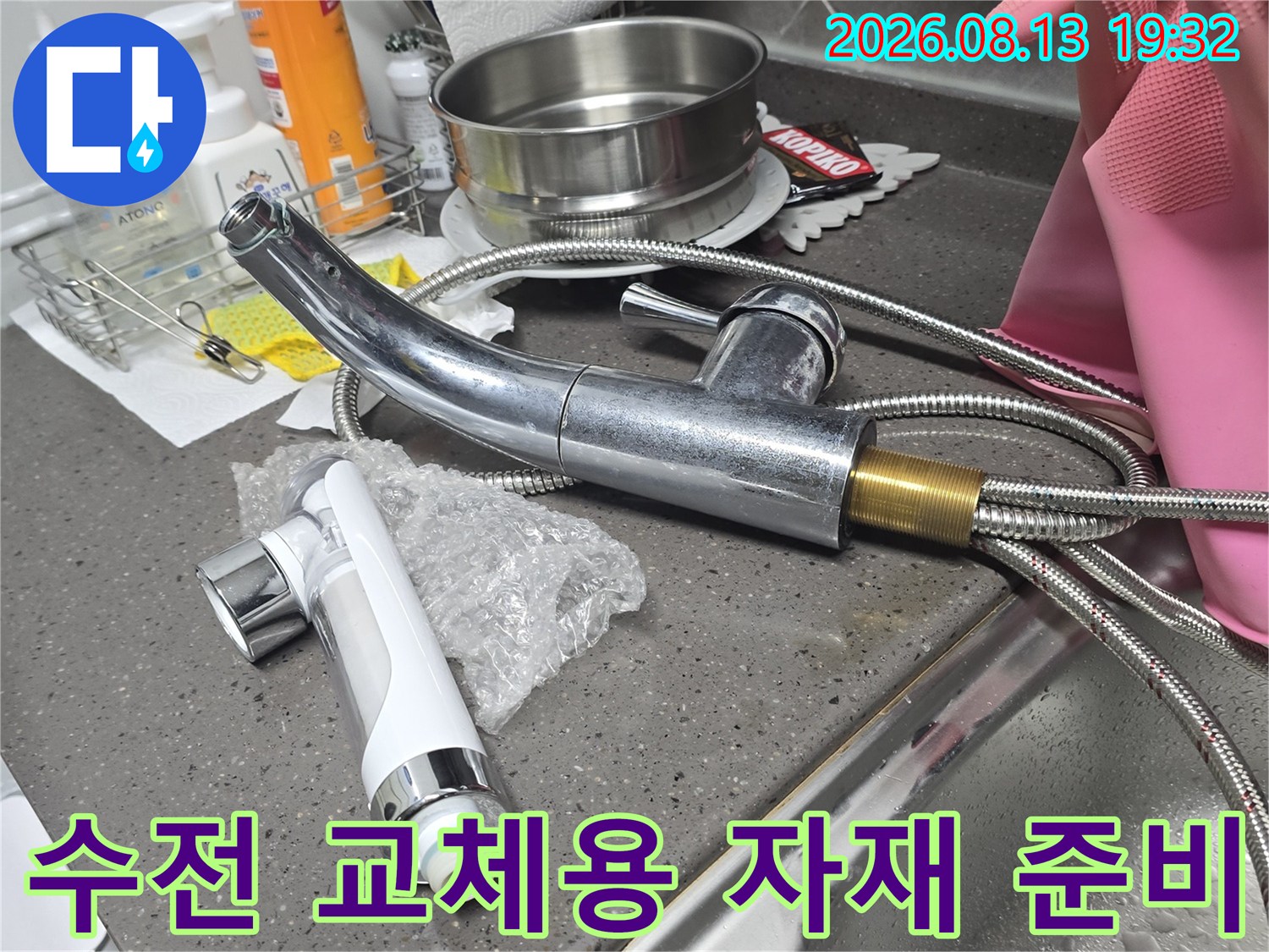 싱크대 하부 배관 교체를 위해 준비된 새 수전과 기존 호스 구성