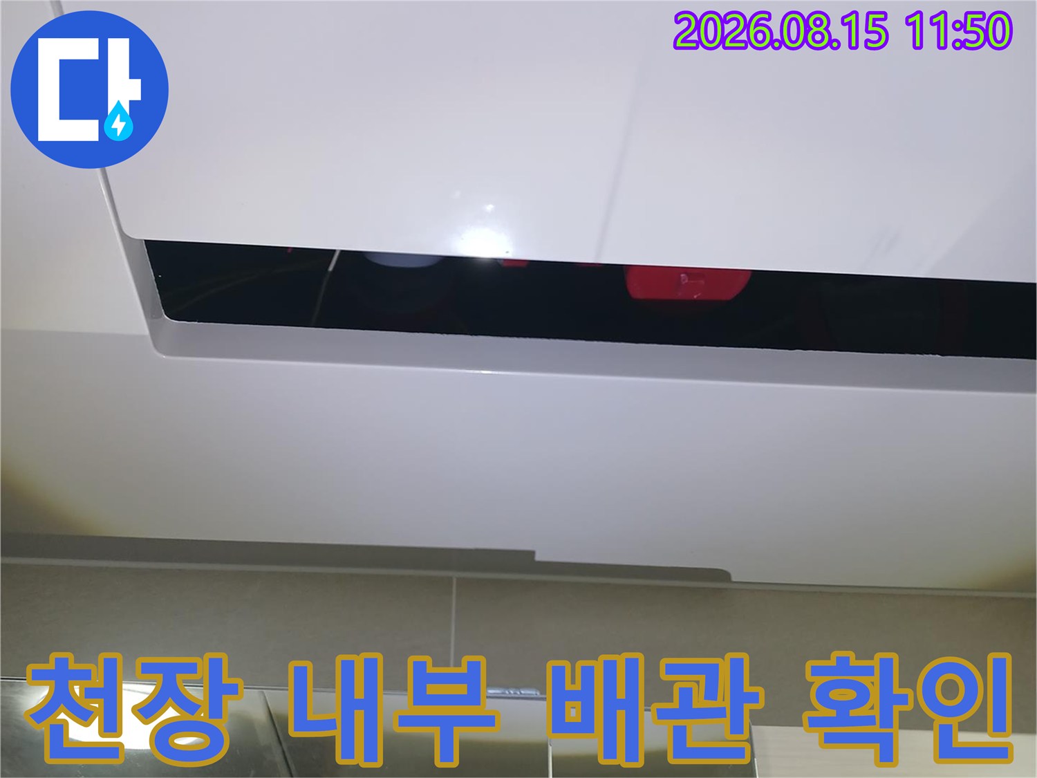 아파트 천장 내부-배관 연결 부위의 손상 여부를 점검하고 있습니다.
