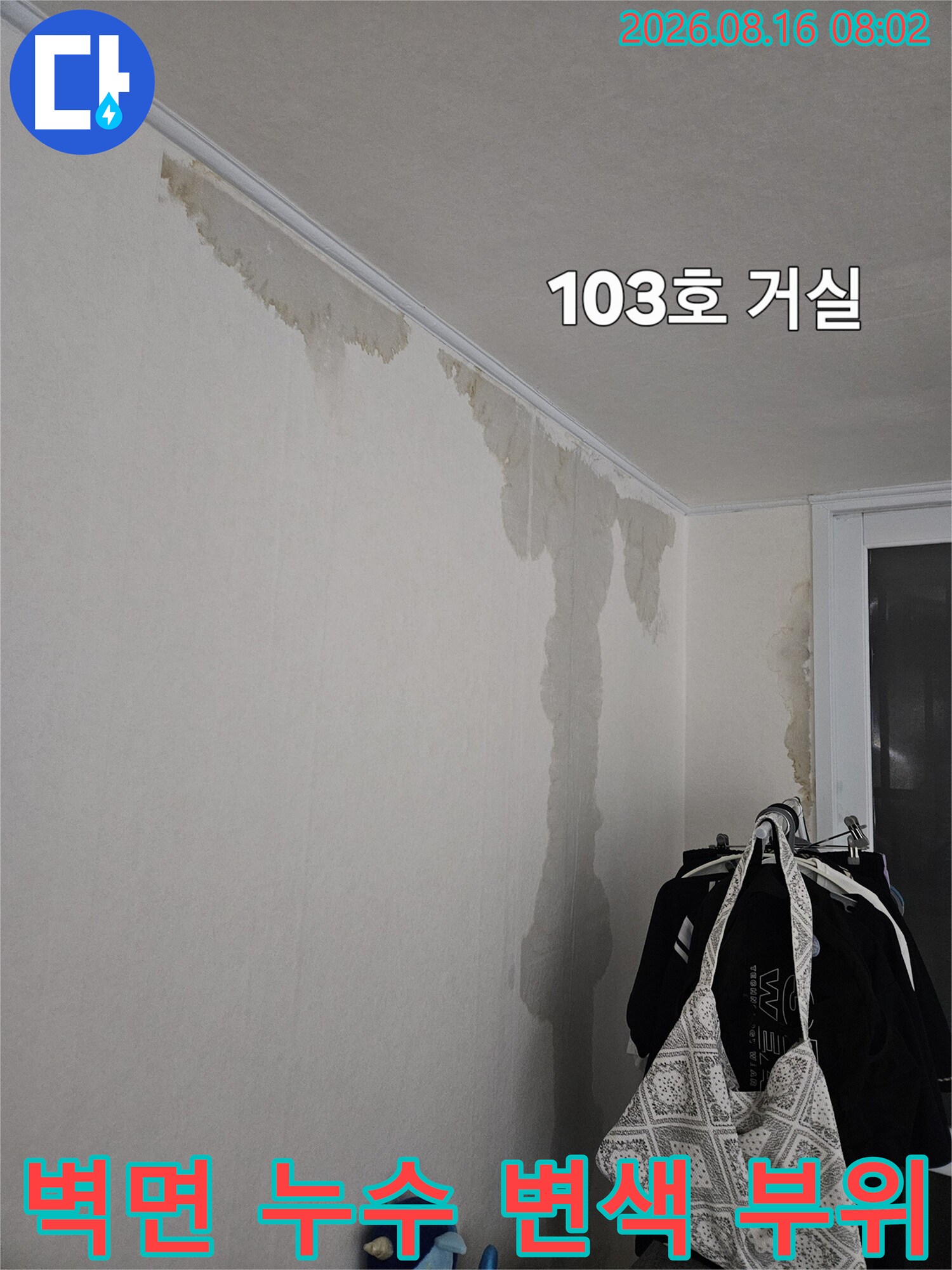 하얀 벽지가 물에 젖어 갈색으로 변한 거실 벽면 모습