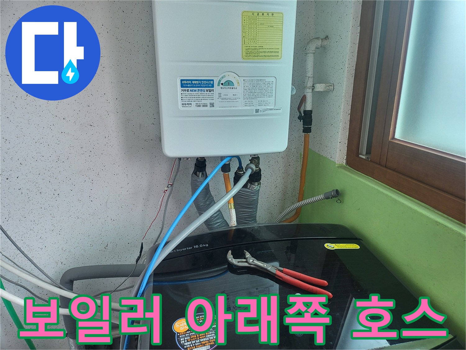 보일러 하단의 은색 금속 배관과 파란색 급수 호스