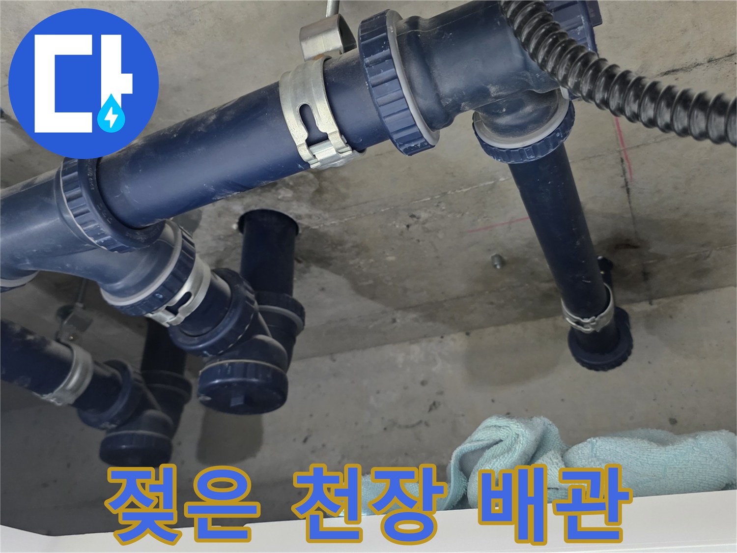 천장 내부 파란색 배관과 젖어 있는 콘크리트 바닥면