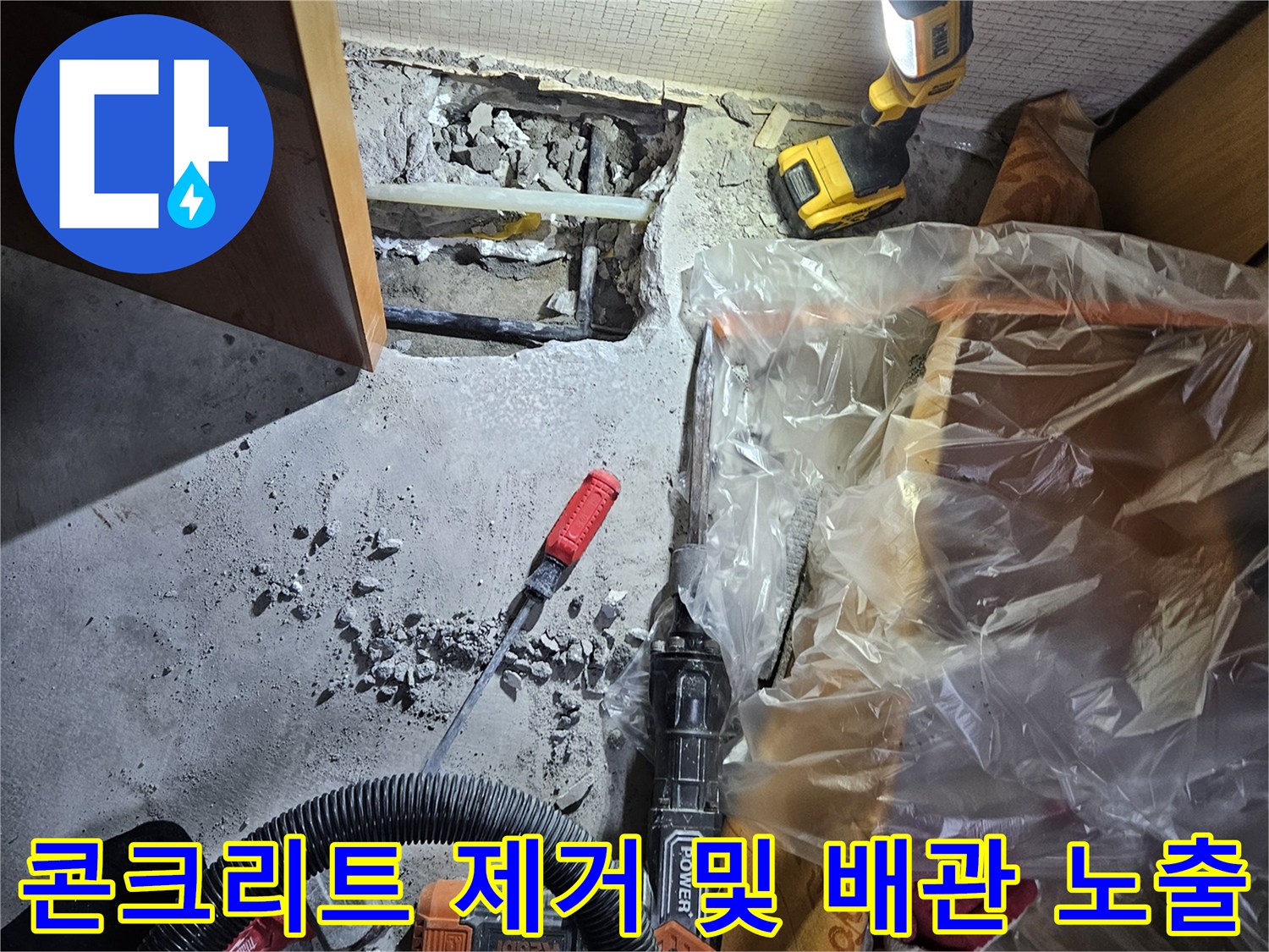 바닥 굴착 현장-드러난 매립 배관과 작업용 드릴 장비