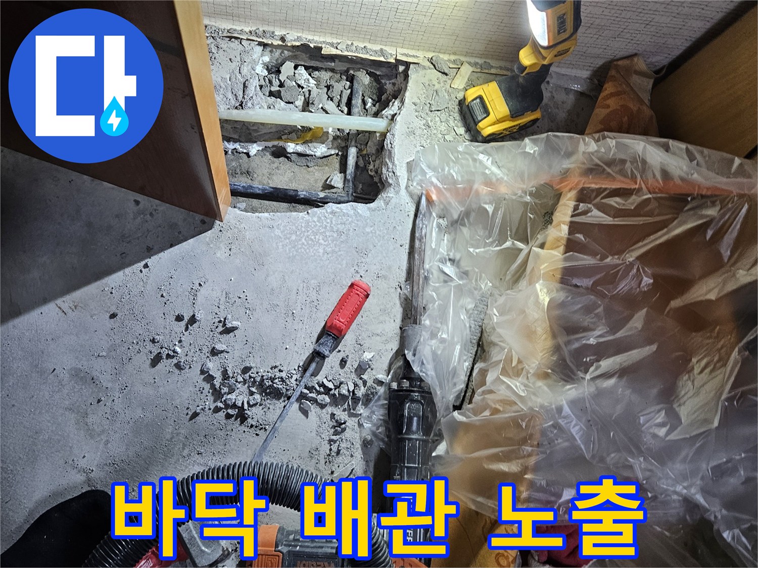 콘크리트 제거-드러난 매립 배관과 작업 장비