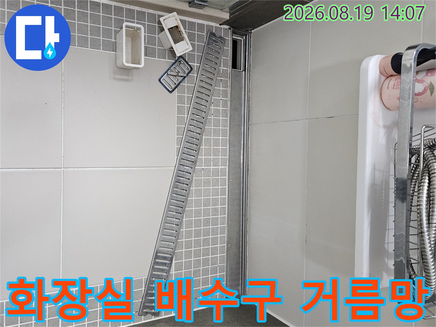 긴 형태의 스테인리스 배수구 거름망과 바닥 타일 상세 사진
