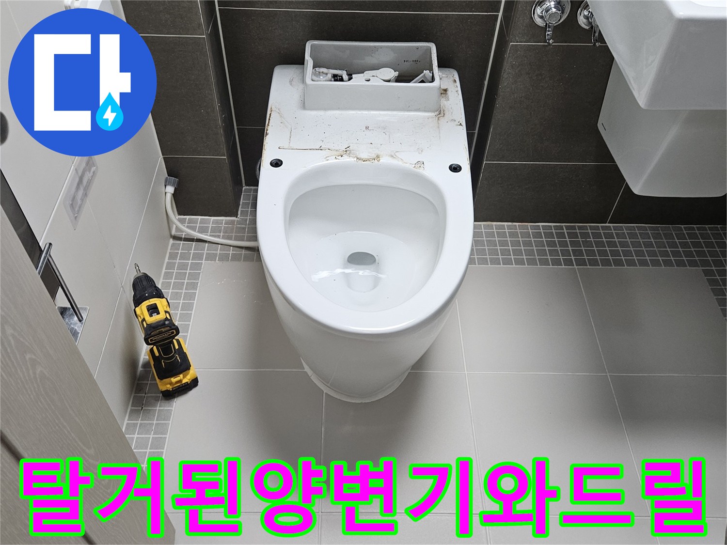 양변기가 분리된 상태에서 바닥에 놓인 전동 드릴 장비