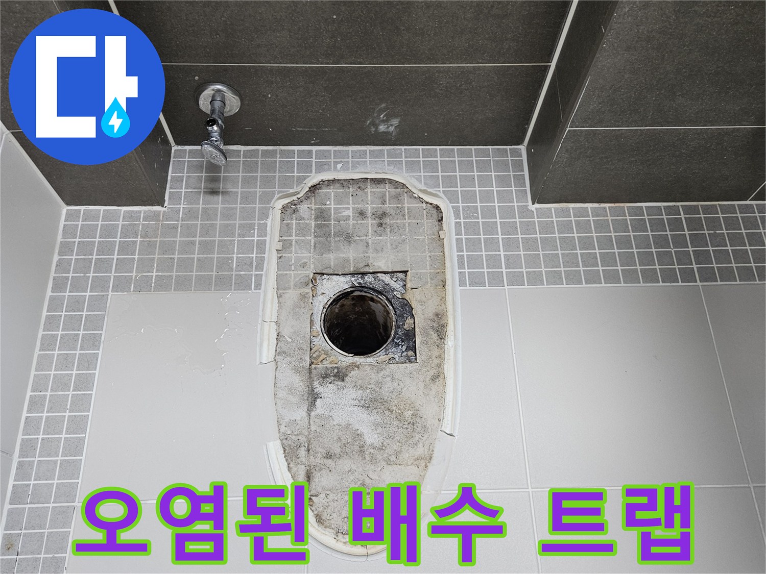 하수구 배관 입구의 침식된 흔적과 오염된 타일