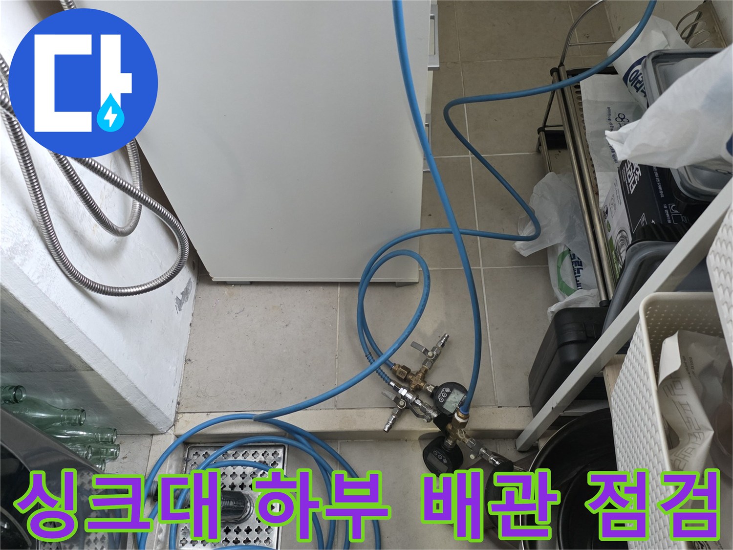 물샘 진단 현장-압력계와 호스가 연결된 싱크대 아래쪽 배수구 주변