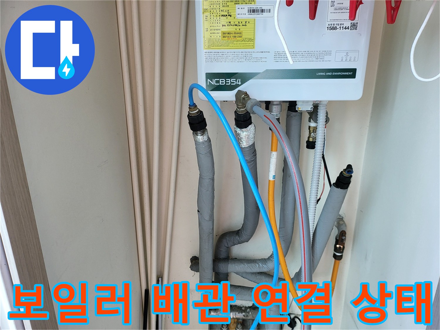 보일러 하단에 연결된 다양한 색상의 급수 및 온수 배관 모습