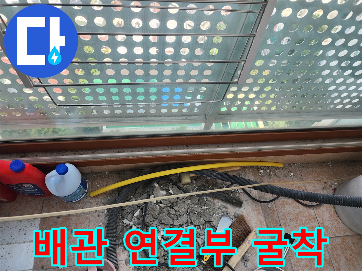 세탁실 바닥의 파손된 부위와 노출된 배관의 모습