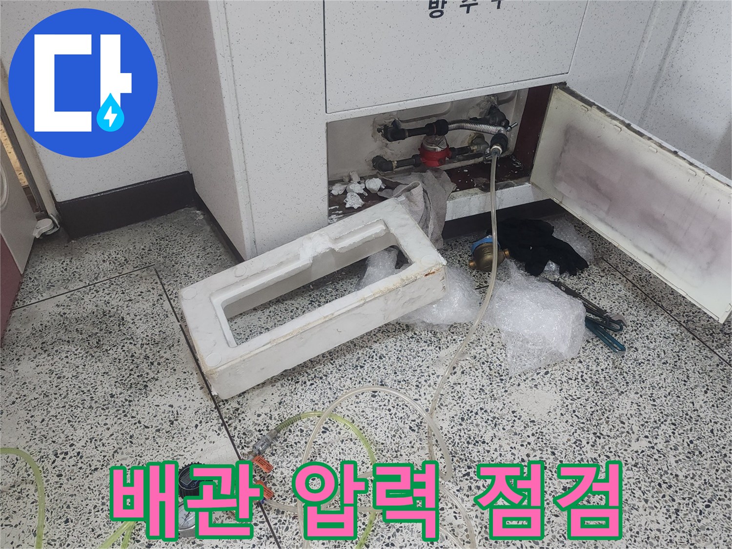 싱크대 하부장에서 진행하는 배관 공압 검사 장비 모습