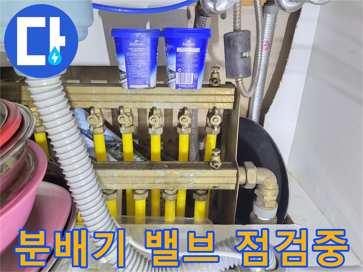 금속 분배기와 노란색 난방 배관의 연결 부위 상세