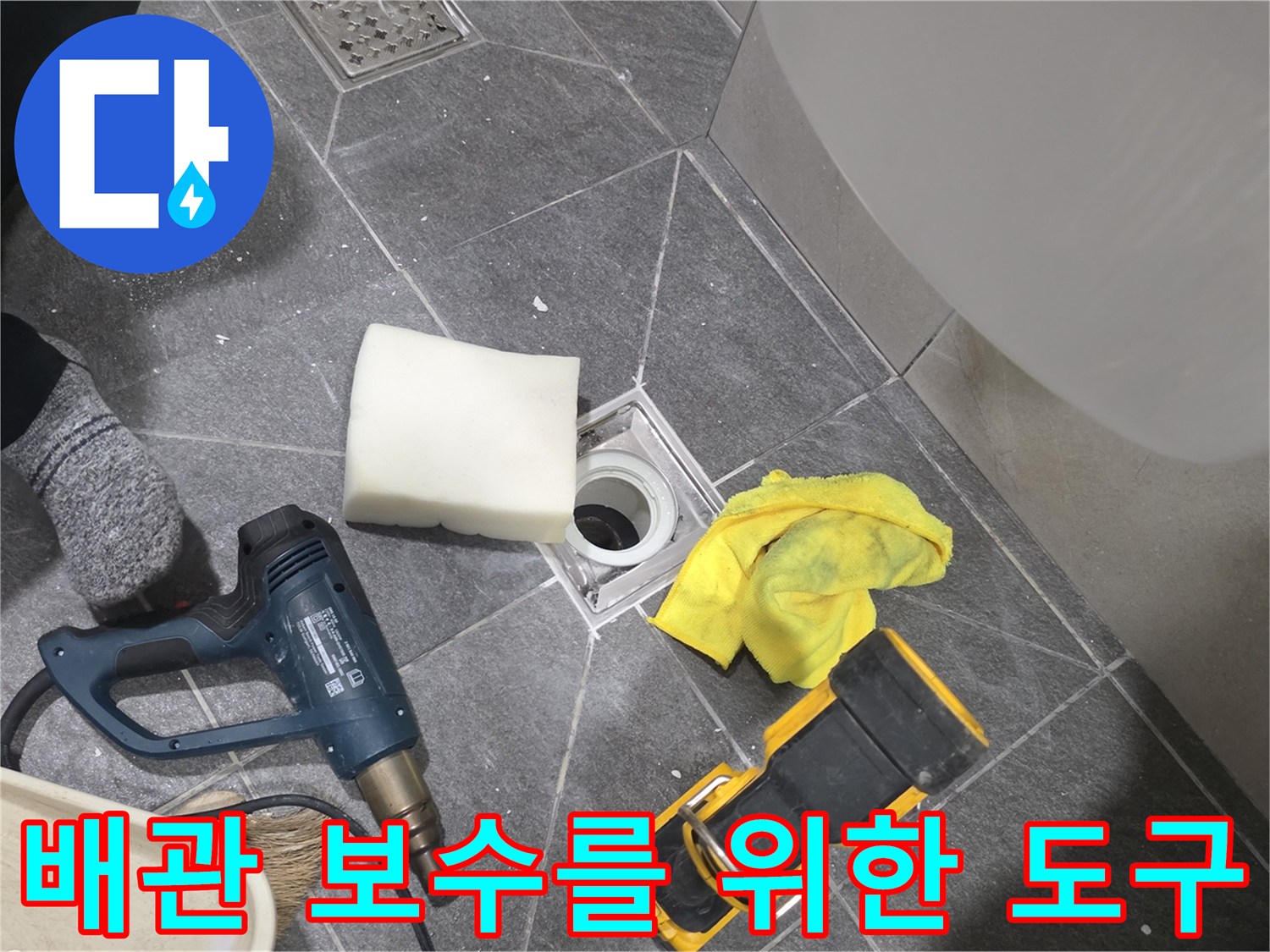 배수구 주변의 누수 지점 확인을 위해 정돈된 공구와 청소 용품