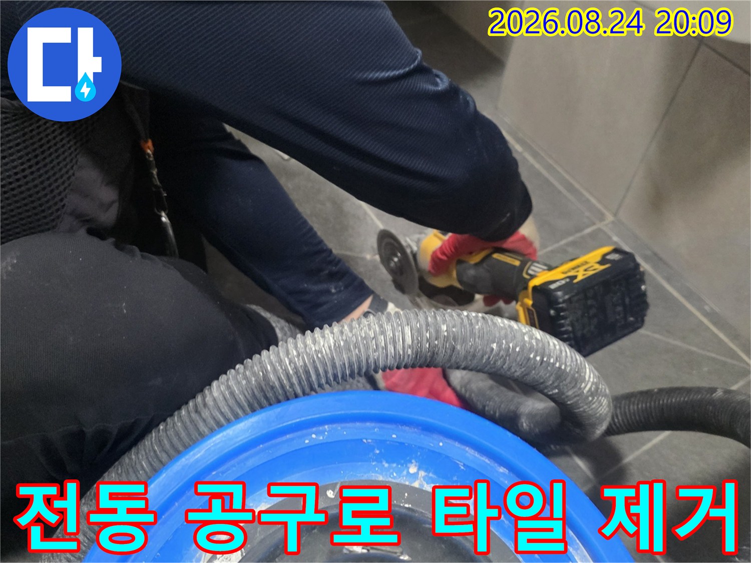 타일 절단용 그라인더와-먼지 흡입 호스가 연결된-배수구 주변 작업 모습