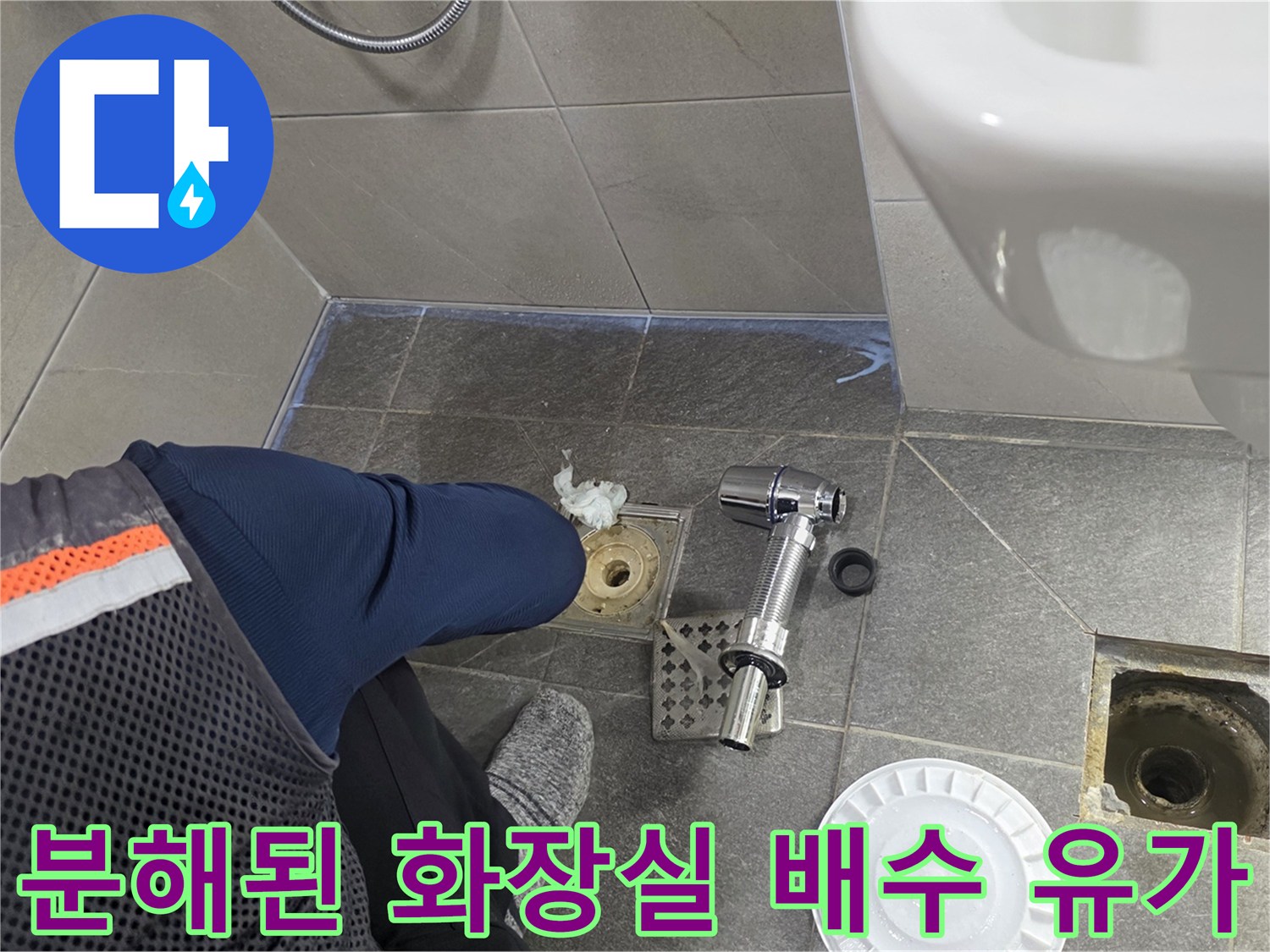 화장실 바닥 배수구 주변의 탈거된 부속품과 노출된 배관 입구