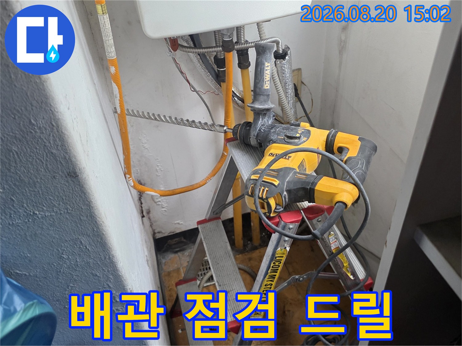 배관 작업을 위해 사다리에 배치된 전동 드릴과 장비들입니다.