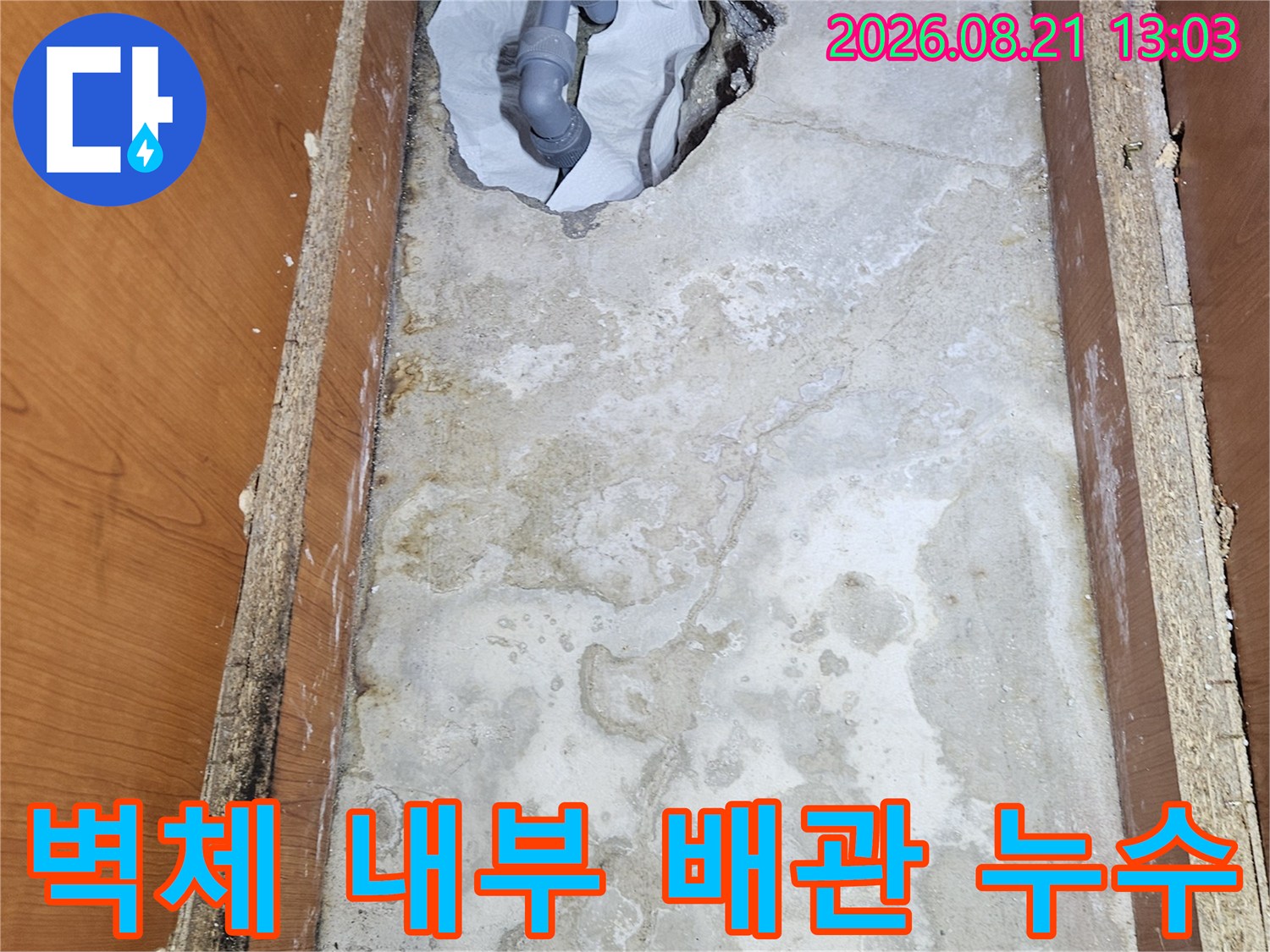 싱크대 하단 벽면-물이 새어 나와 젖어 있는 콘크리트와 노출된 배관
