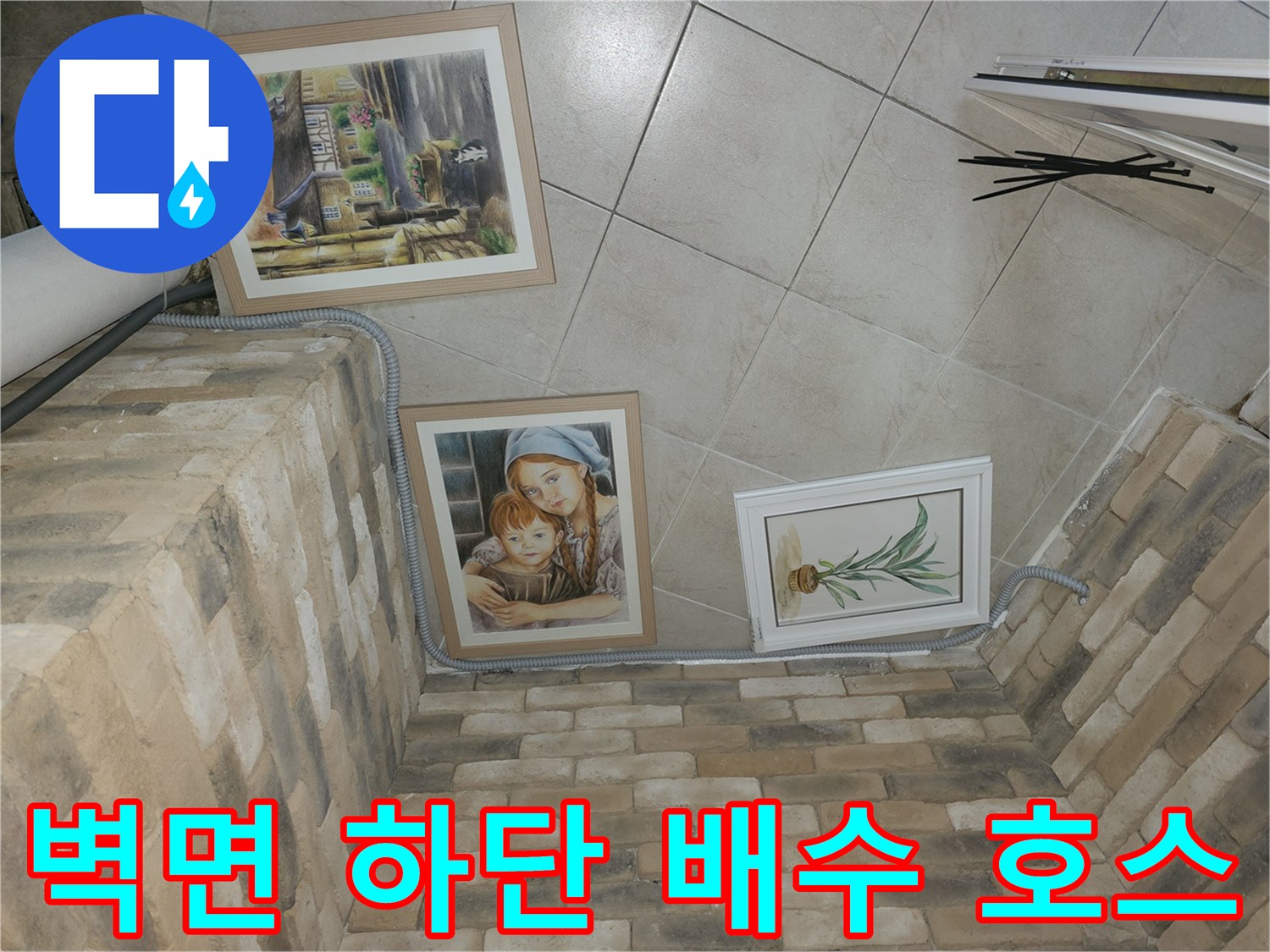 벽돌 마감 벽체에 설치된 회색 드레인 배관 사진