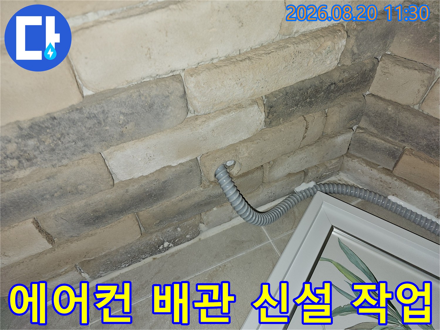 벽면 석재 타공 부위로 연결된 에어컨 드레인 배관 설치 모습