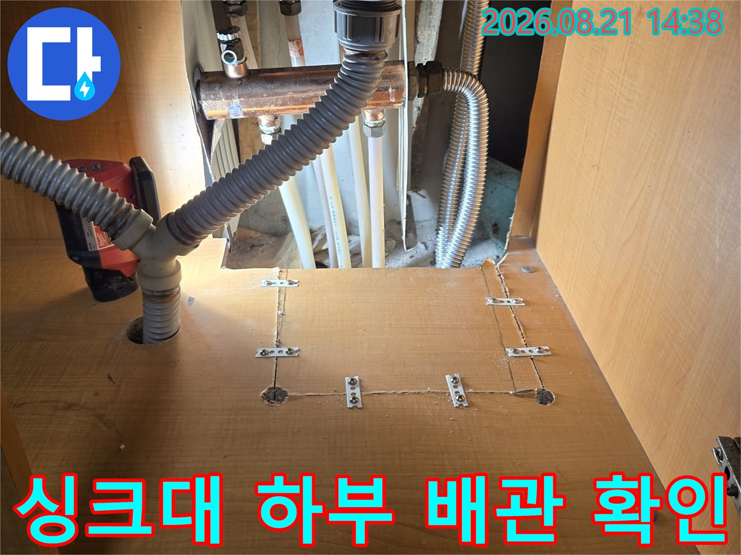 싱크대 아래 금속 관과 회색 주름관의 연결 부위 상세 사진