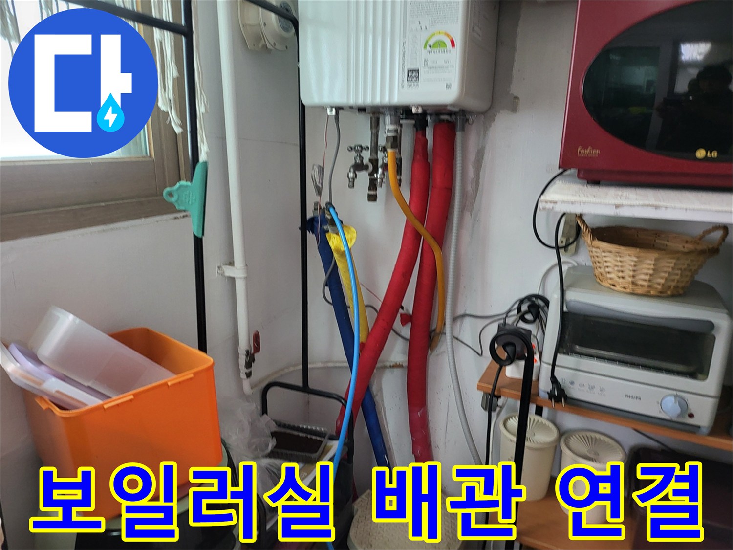 보일러 하단 밸브와 빨간색 및 파란색 유연 배관의 모습