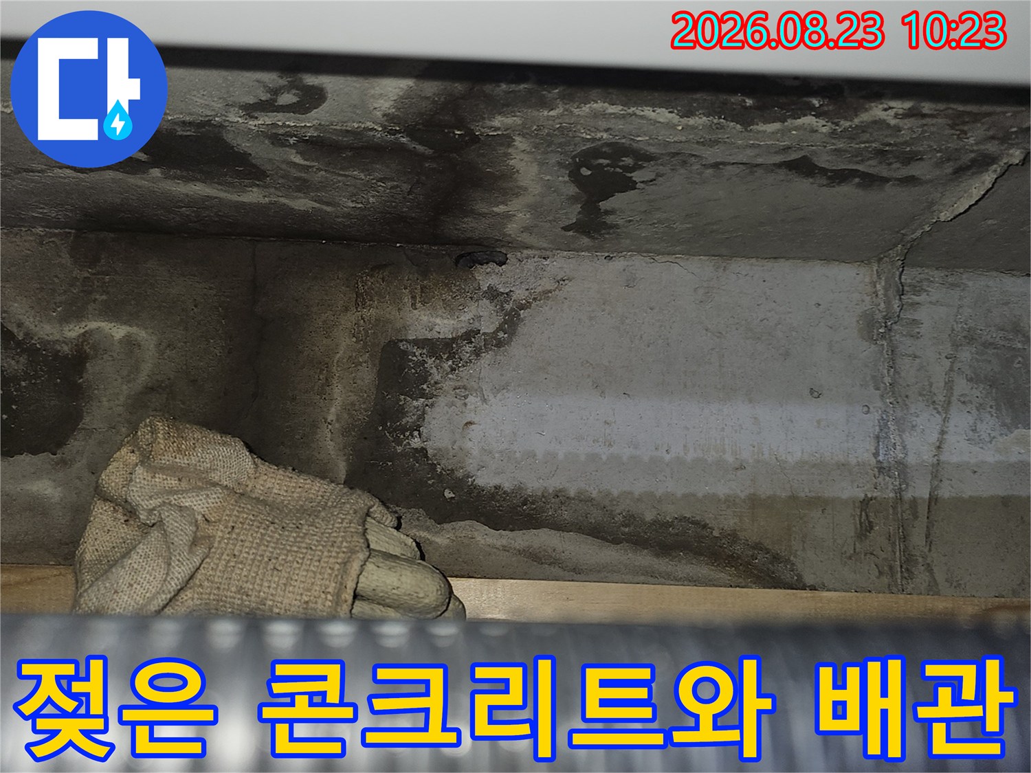 천장 내부의 젖은 콘크리트 벽면과 배관 노출 부위