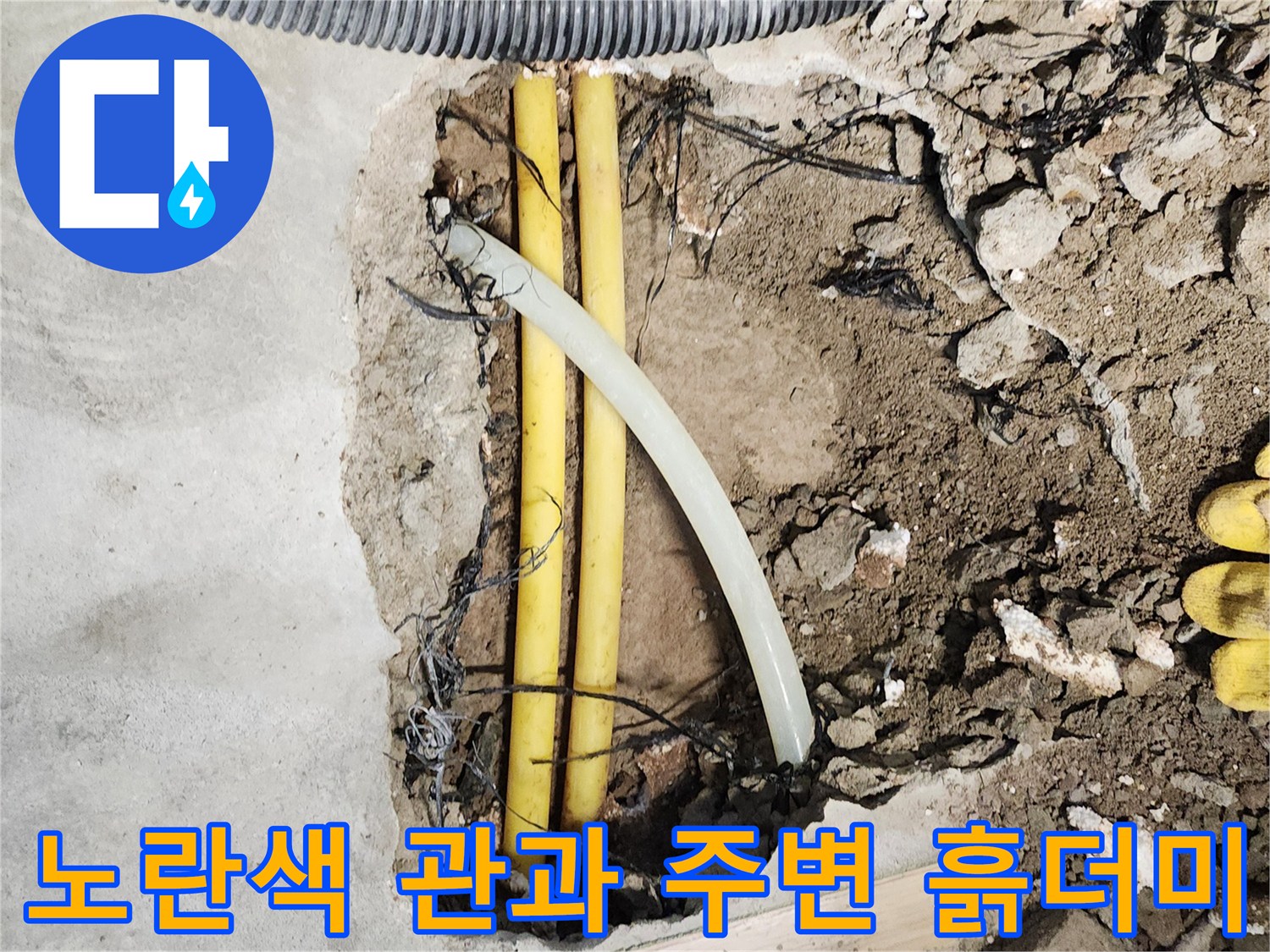 공사 중 드러난 노란색 배관과 파헤쳐진 바닥 흙의 모습