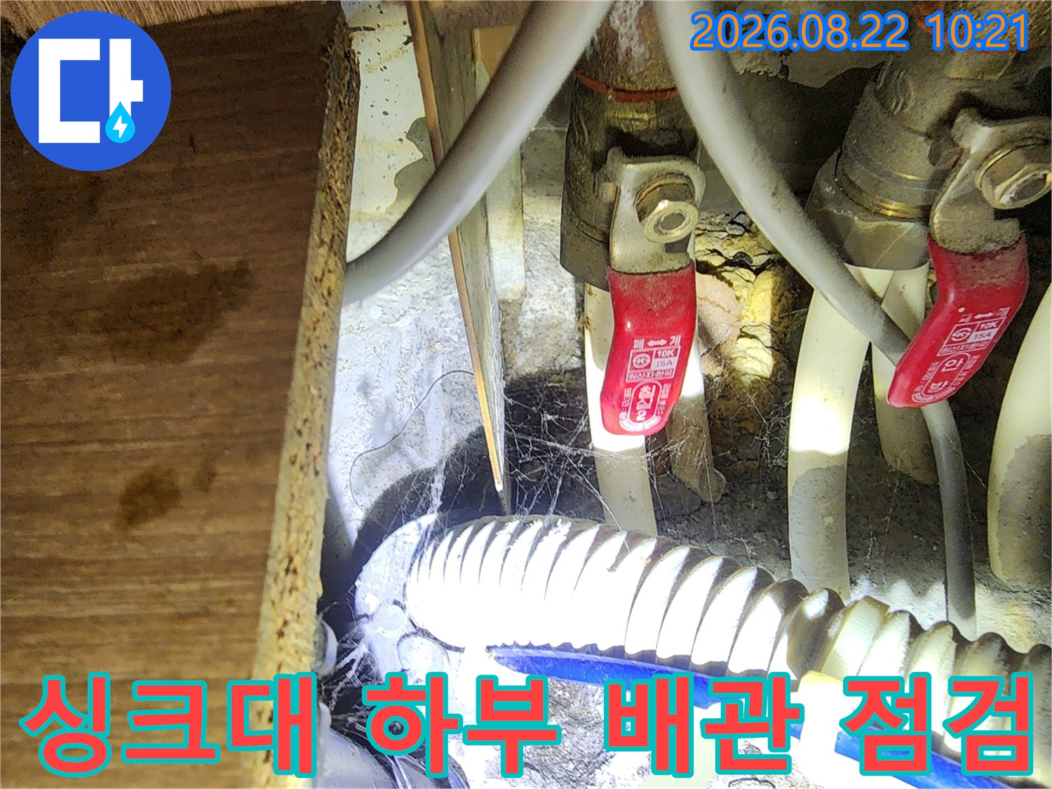 싱크대 밑부분의 밸브와 호스들이 모여 있는 모습