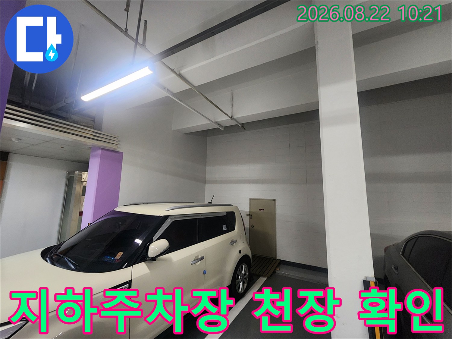 흰색 차량 주변-지하주차장 천장의 배관과 조명 상태
