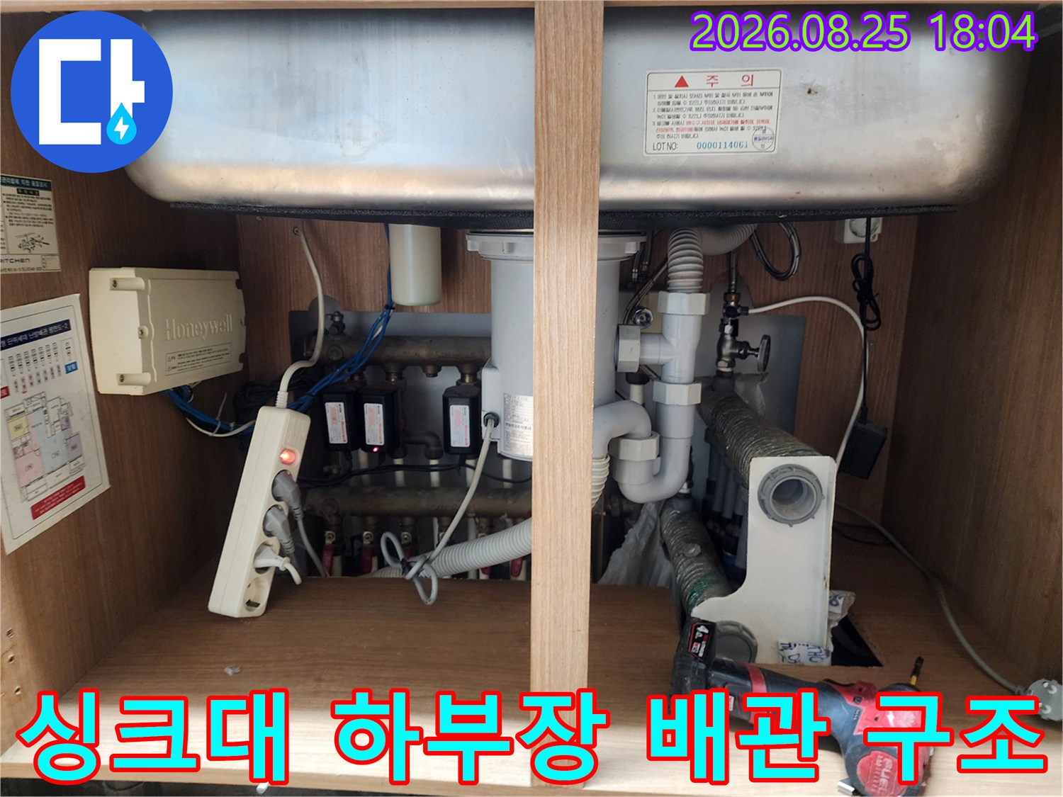 싱크대 하단 수납장 내부에 노출된 각종 배관과 밸브들의 모습