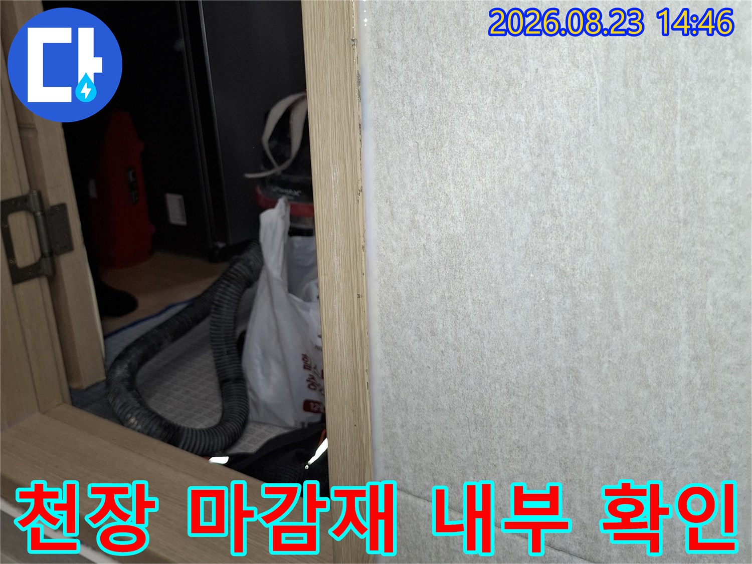 천장 단열재와 목재 구조물 사이의 틈을 점검하는 사진입니다.