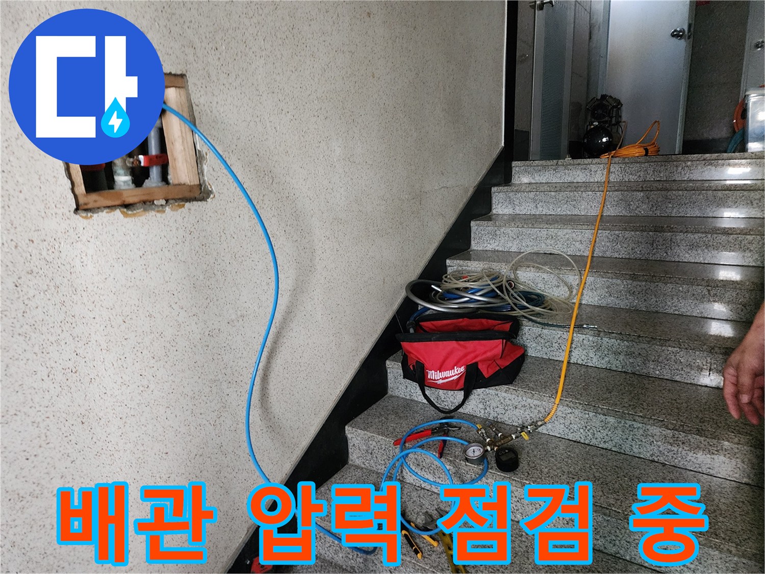 파란색 호스를 연결하여 배관 내부의 기밀성을 테스트하는 현장