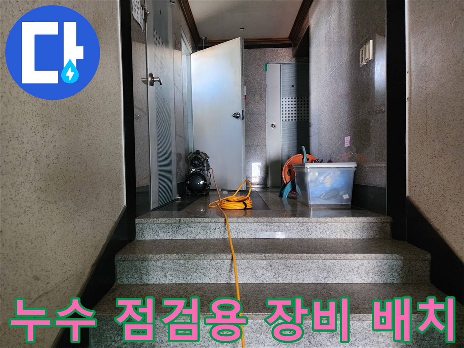 화장실 통로에 놓인 작업용 석션기와 전선 케이블