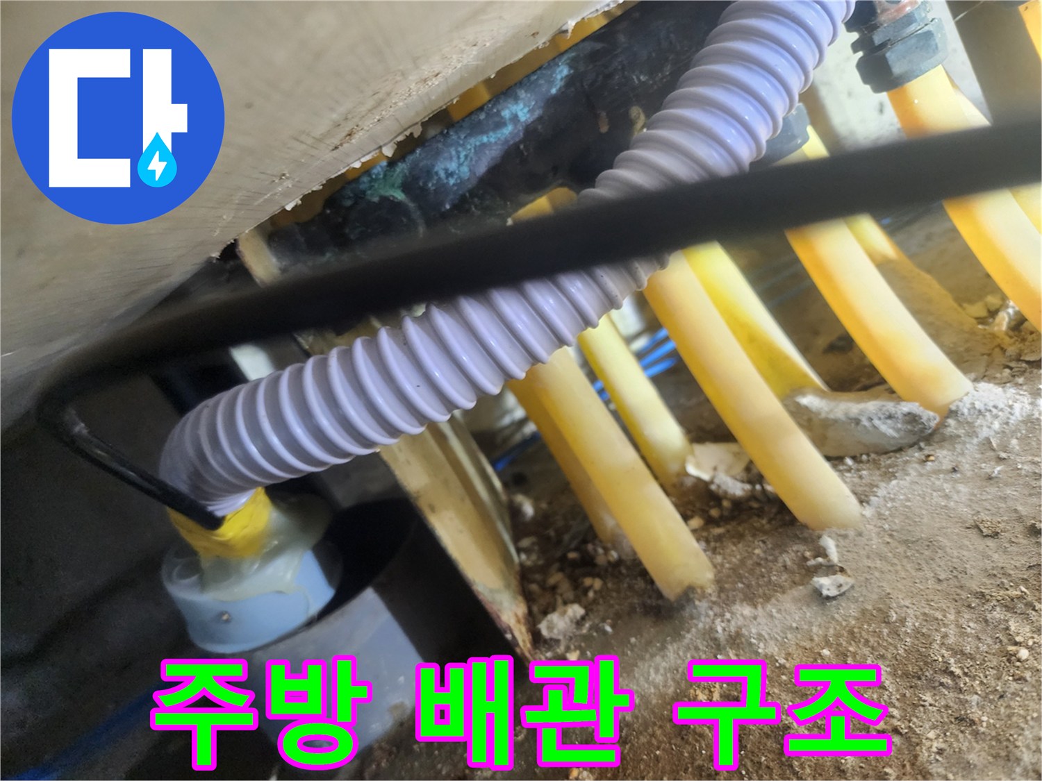 복잡하게 얽힌 싱크대 하부 노란색 PVC 배관들
