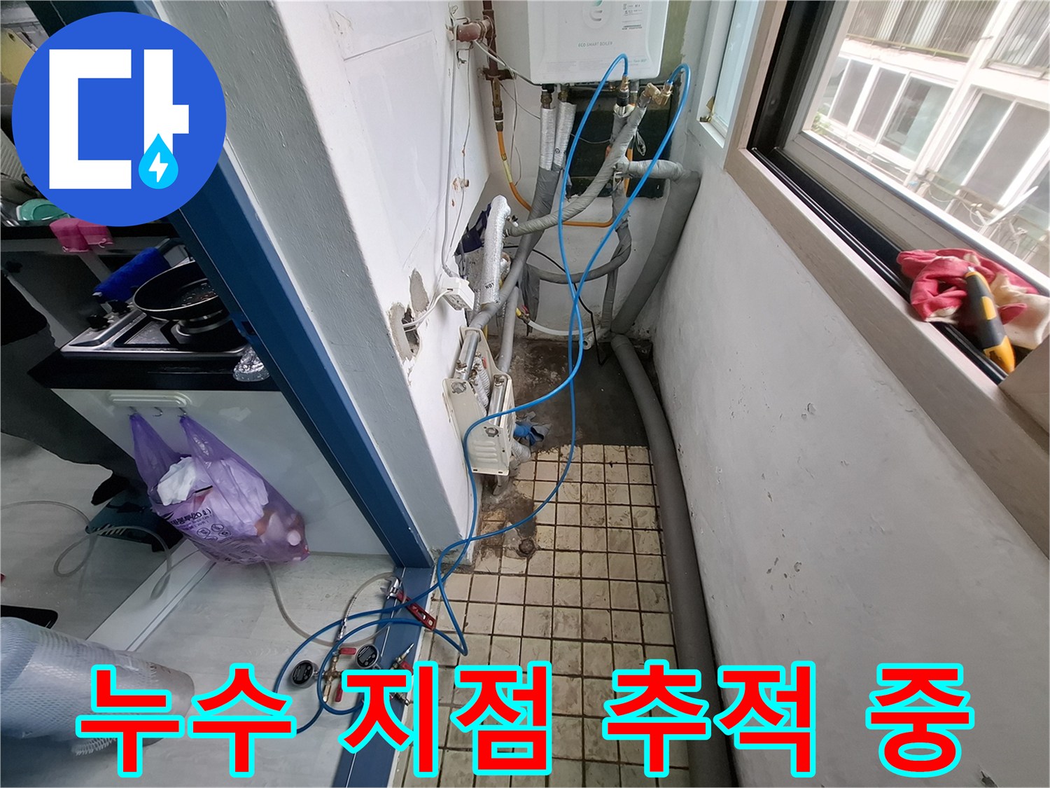 배관을 따라 연결된 파란 호스와 바닥 타일 부위의 점검 모습