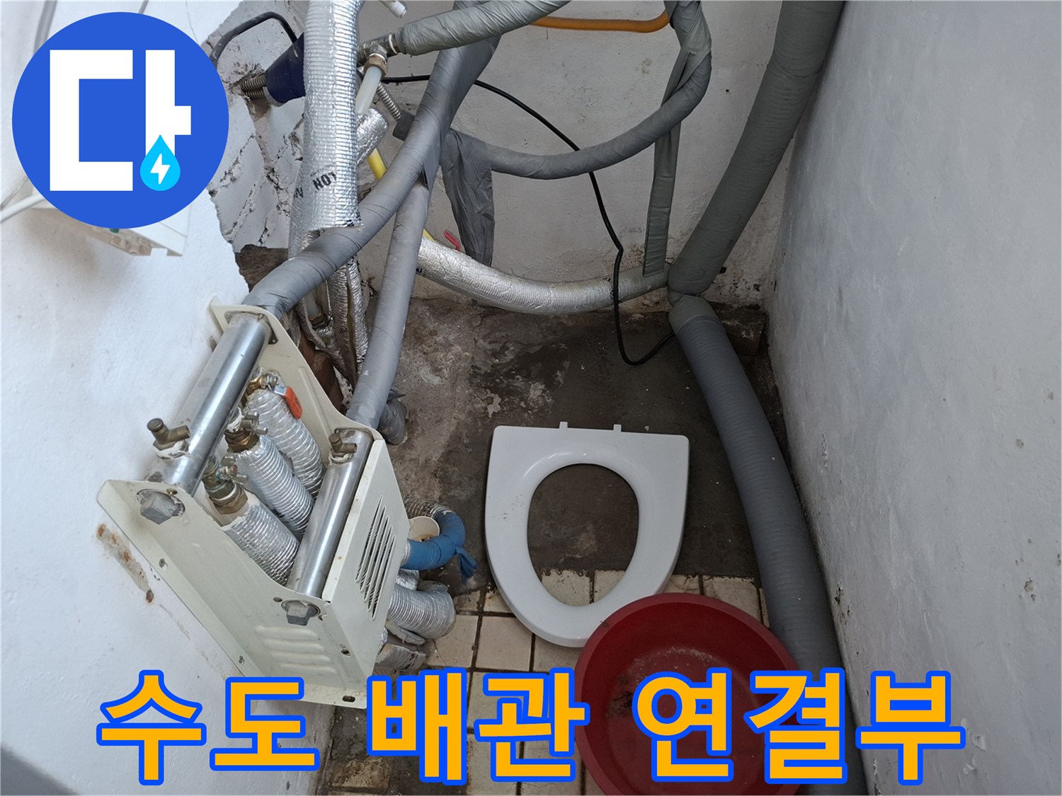 은박 보온재로 감싸진 배관과 바닥에 놓인 대야